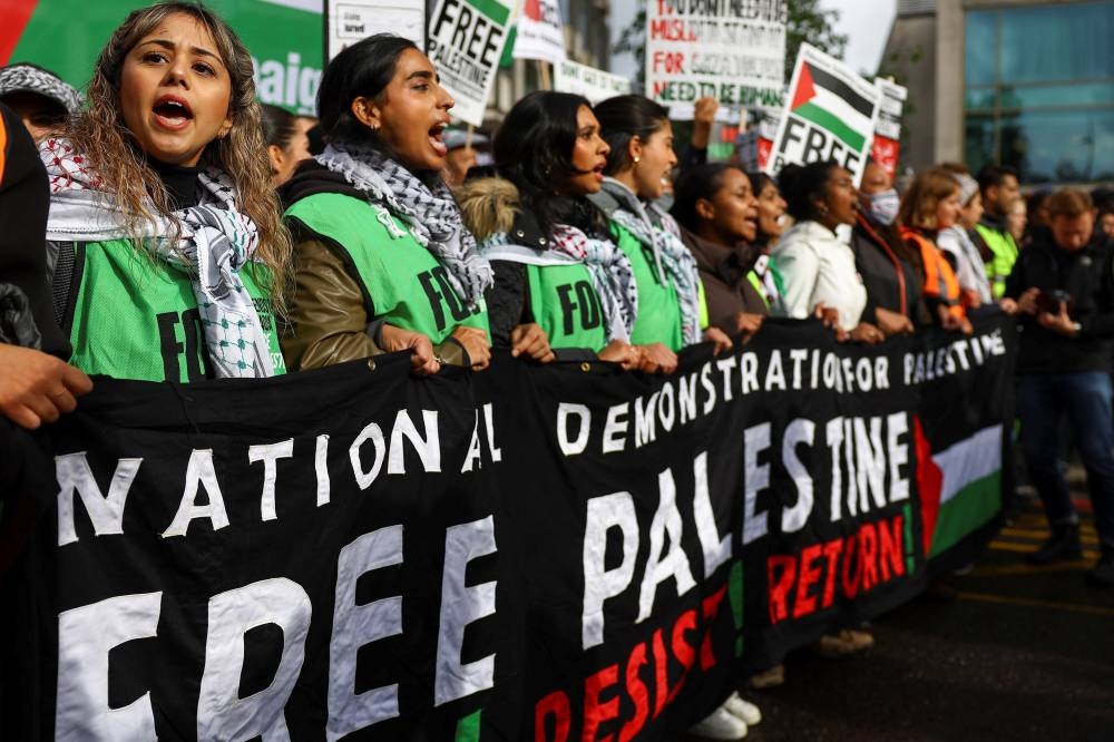 Demonstrators hold a banner, at a protest in solidarity with Palestinians in Gaza, amid the ongoing conflict between Israel and the Palestinian group Hamas, in London, Saturday. REUTERS