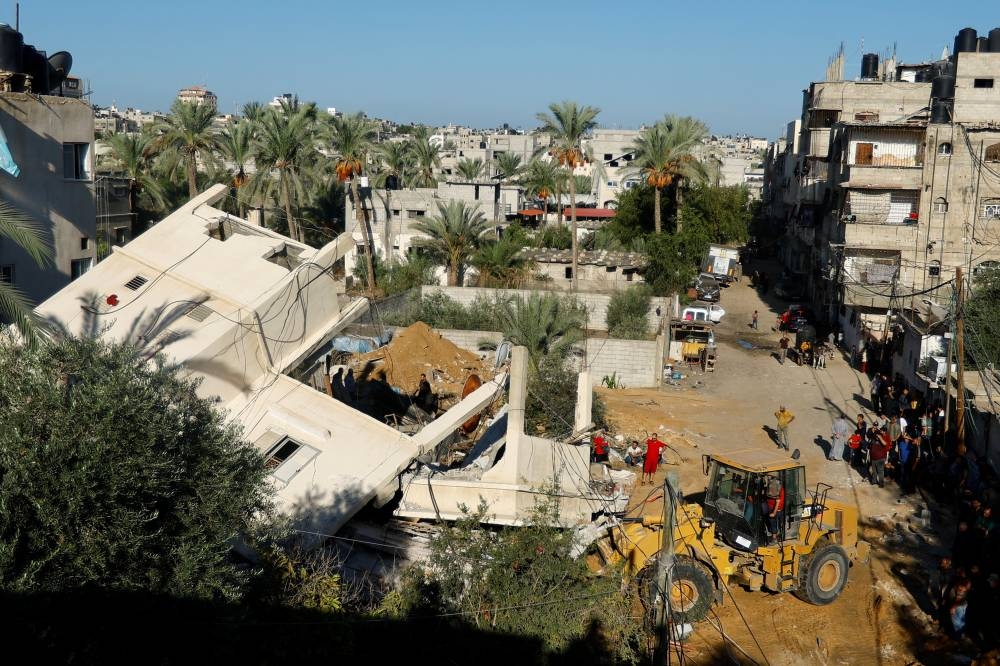 Palestinians search for casualties at the site of an Israeli strike on a house, in Khan Younis, in the southern Gaza Strip, Saturday. REUTERS