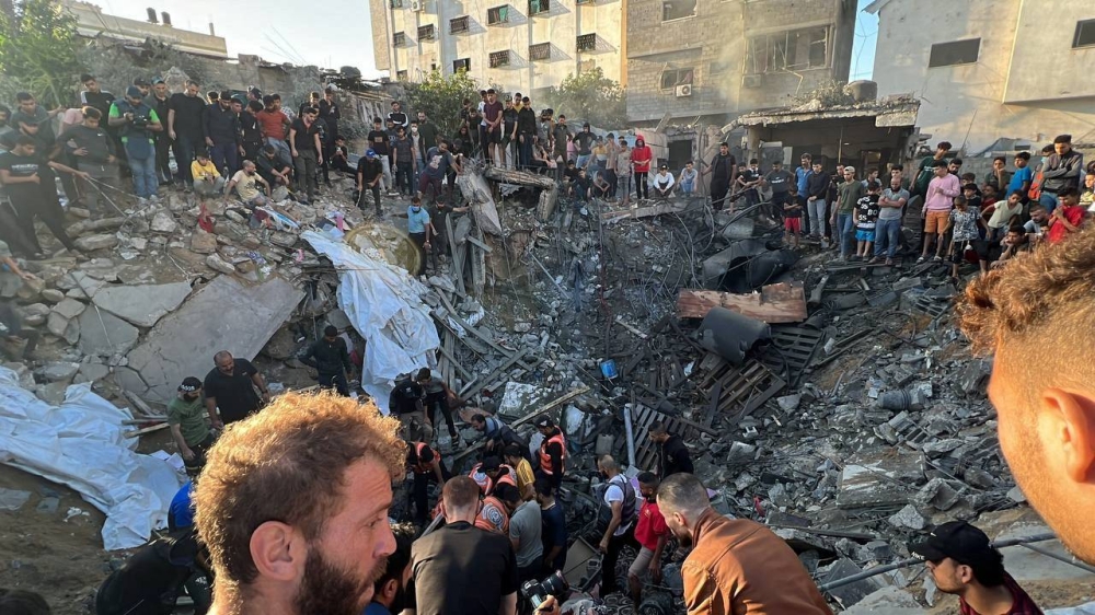 Palestinians gather at the site of an Israeli strike on a house, amid the ongoing conflict between Israel and Palestinian Islamist group Hamas, in Gaza City, Saturday. REUTERS