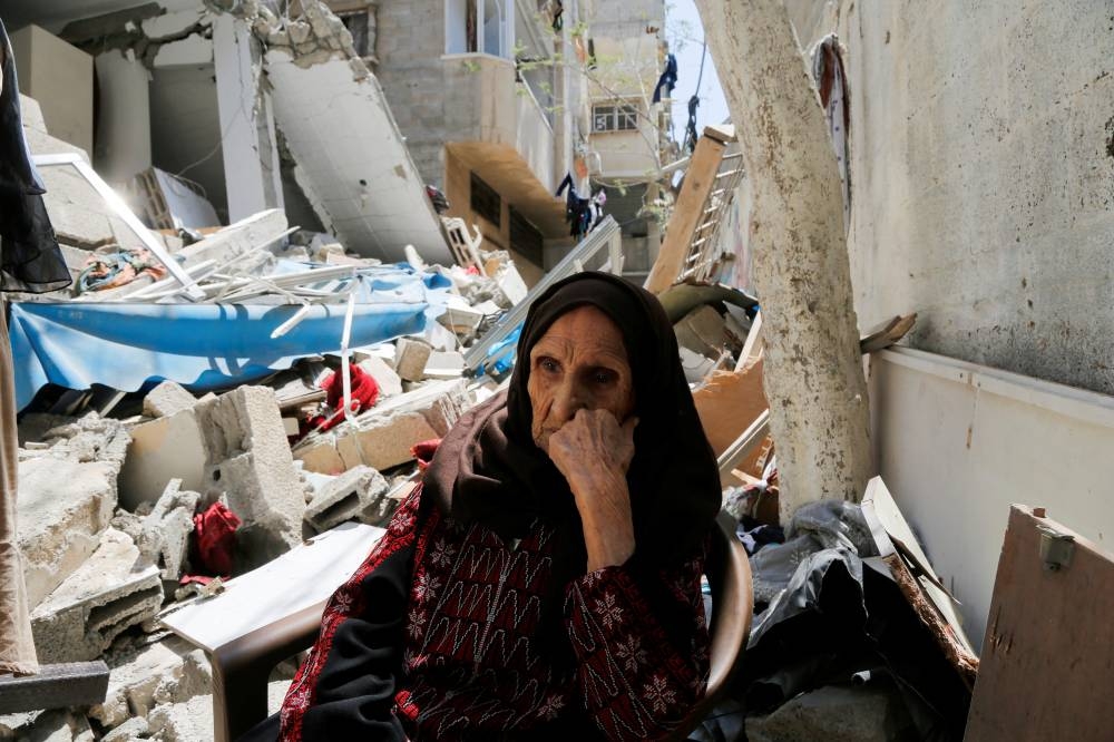 Palestinian woman Intisar Muhana, 97, who was forced to flee al-Masmiyya village during the 'Nakba' in 1948 and whose house was destroyed in an Israeli strike in the recent Israel-Gaza fighting, sits in front of the rubble of her house, in Gaza City, on May 14, 2023.