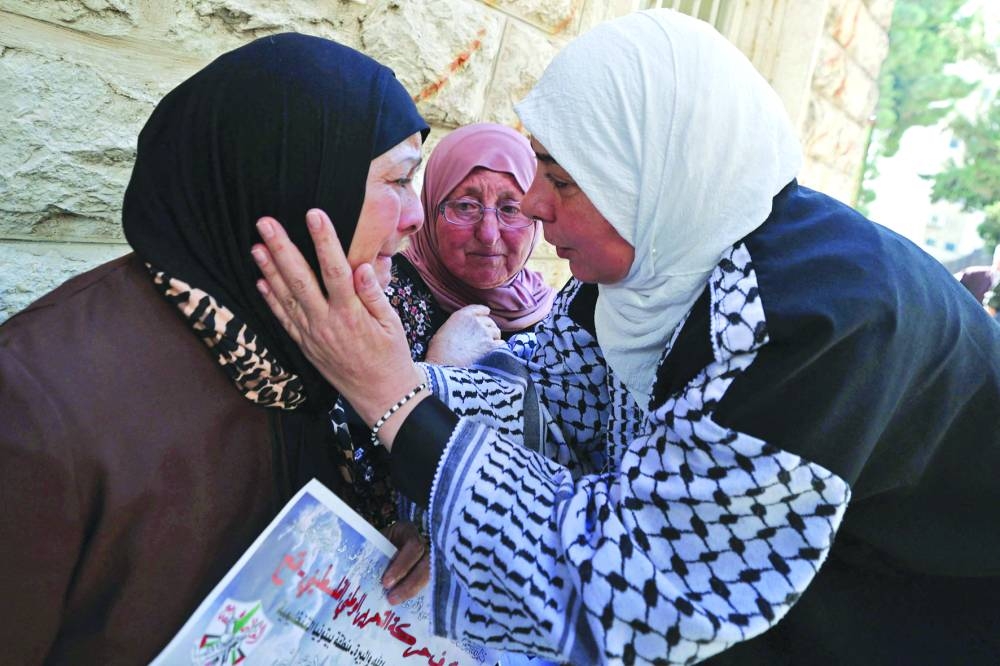 
The grandmother (left) of 15-year-old Suhaib al-Sus, is comforted a day after he was killed during clashes with Israeli soldiers in the Palestinian village of Beitunia, during his funeral in the West Bank city of Ramallah, yesterday. 