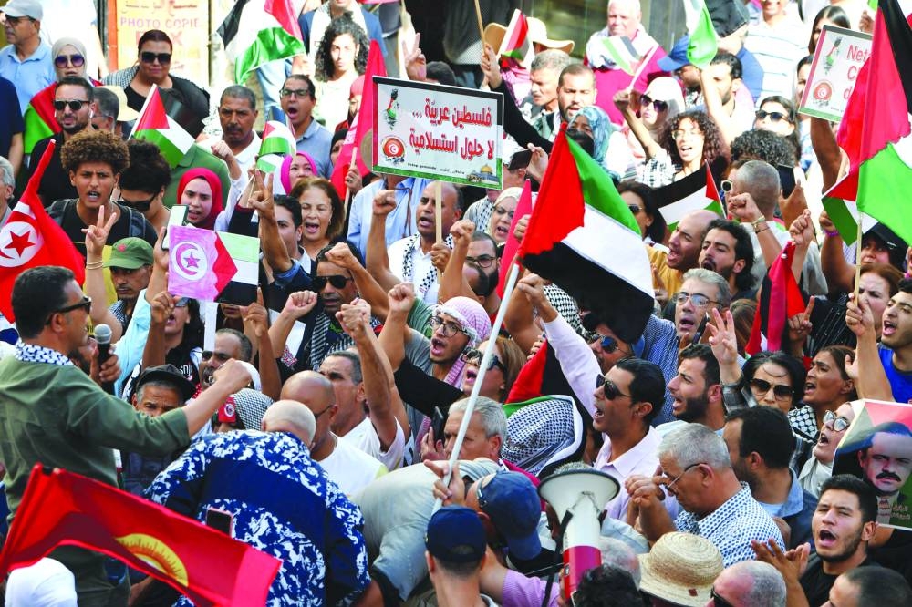
People wave the Palestinian flag during a protest to express their solidarity with Gaza in the Tunisian capital Tunis, yesterday. 