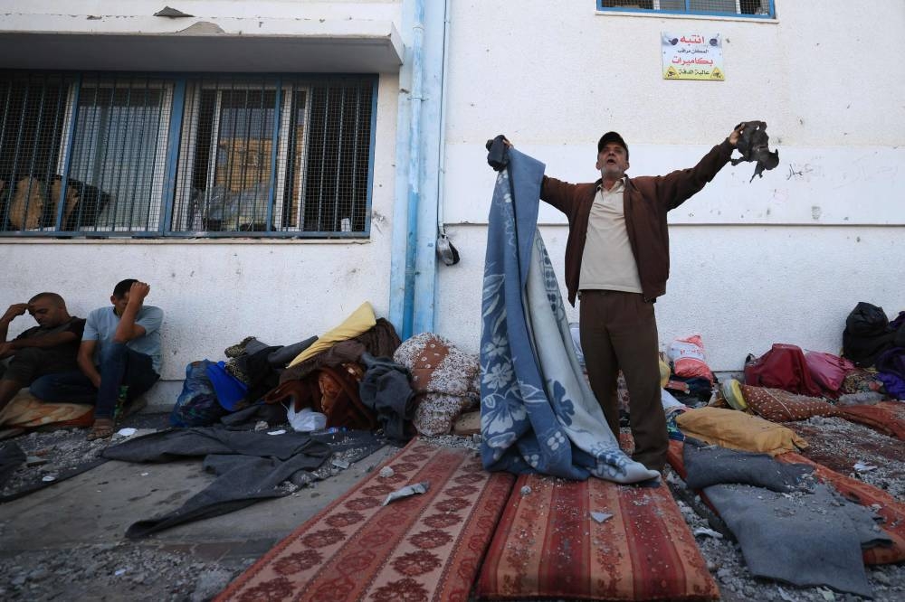 Palestinians react to the debris after an Israeli strike near an United Nations Relief and Works Agency for Palestine Refugees (UNRWA) school in Khan Yunis, in the southern Gaza Strip on Saturday. AFP