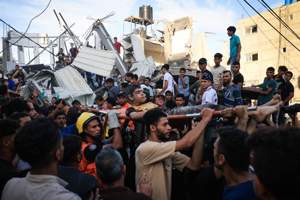 Palestinians evacuate a wounded man after an Israeli strike near an United Nations Relief and Works Agency for Palestine Refugees (UNRWA) school in Khan Yunis, in the southern Gaza Strip on Saturday. AFP