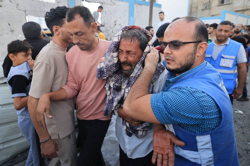 Palestinians evacuate a wounded man after an Israeli strike near an United Nations Relief and Works Agency for Palestine Refugees (UNRWA) school in Khan Yunis, in the southern Gaza Strip on Saturday. AFP