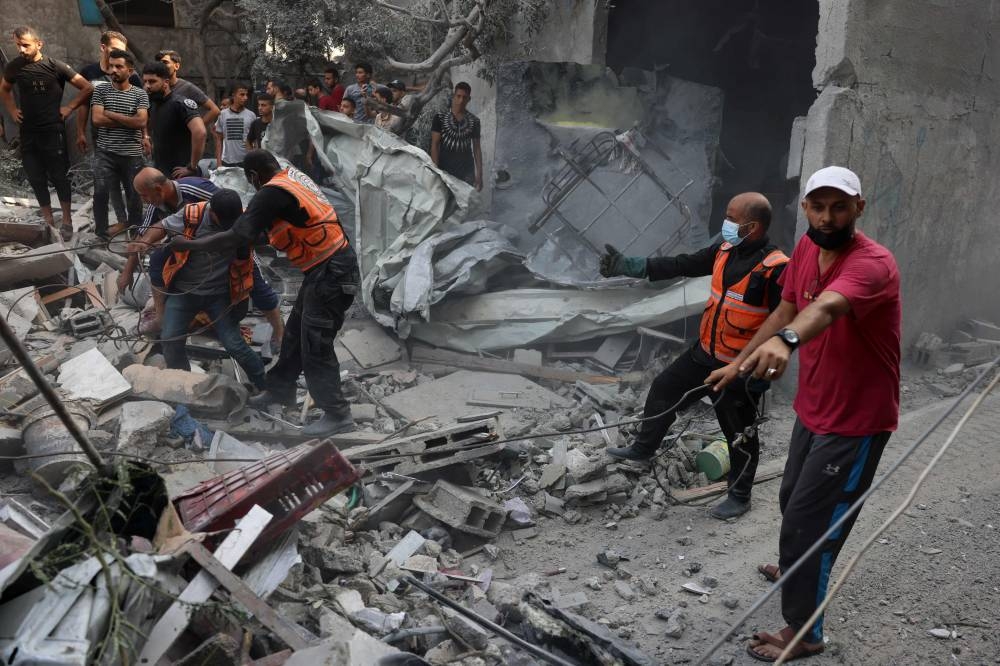 Rescuers search for victims or survivors under the rubble of a house destroyed in an Israeli strike on Rafah in the southern Gaza Strip on Sunday. AFP