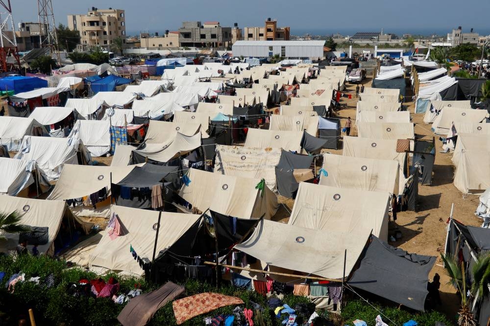 Palestinians, who fled their houses amid Israeli strikes, take shelter in a tent camp at a United Nations-run centre, after Israel's call for more than 1 million civilians in northern Gaza to move south, in Khan Younis in the southern Gaza Strip, on Monday. REUTERS