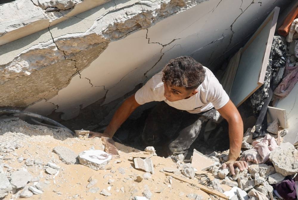 A man inspects as Palestinians search for casualties at the site of an Israeli strike on a house in Khan Younis, in the southern Gaza Strip, on Tuesday. REUTERS