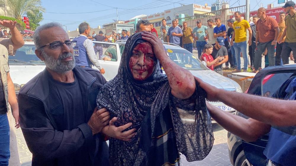 A woman injured in an Israeli strike is assisted, as she arrives at a hospital in Khan Younis in the southern Gaza Strip on Tuesday. REUTERS