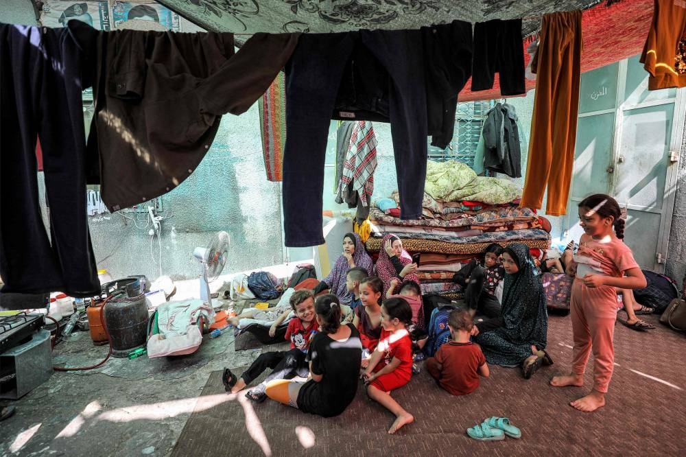 Displaced families, who returned from Khan Yunis in the southern Gaza Strip to the north due to the dangers and difficulties they faced there under Israeli bombardment, take shelter at Al-Shifa hospital in Gaza City on Wednesday. AFP
