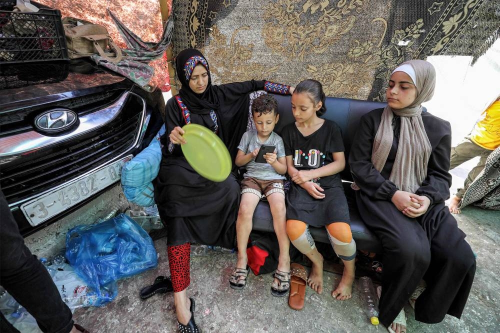 Women and children from displaced families, who returned from Khan Yunis in the southern Gaza Strip to the north due to the dangers and difficulties they faced there under Israeli bombardment, take shelter at Al-Shifa hospital in Gaza City on Wednesday. AFP