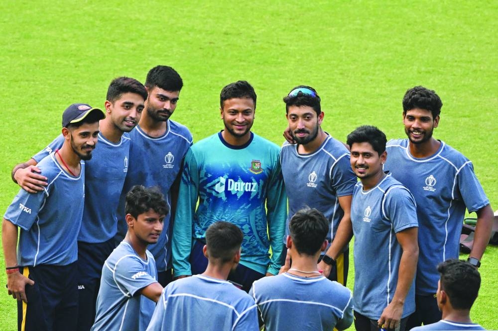 
Bangladesh’s captain Shakib Al Hasan (centre) poses for a photograph with local net bowlers during a practice session on the eve of their 2023 ICC Men’s Cricket World Cup match against Netherlands at the Eden Gardens Stadium in Kolkata. (AFP) 
