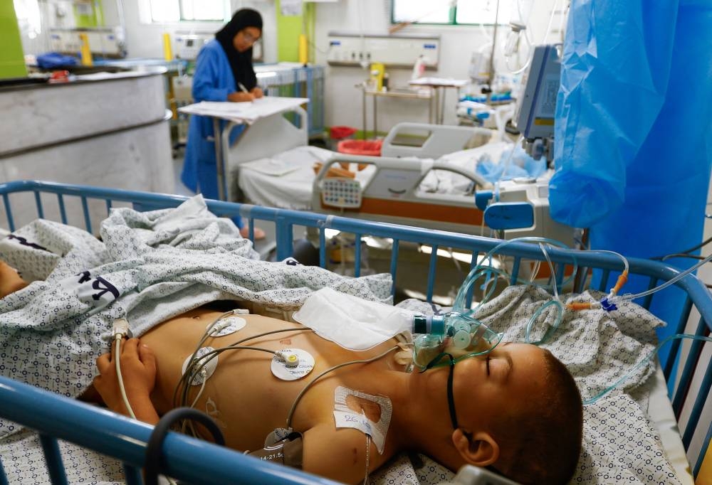 A Palestinian boy, who was wounded in Israeli strikes, lies on a bed at the Intensive Care Unit (ICU) of Nasser hospital, as doctors say they are only able to accept critical cases that are in need of surgery, while the unit is filled up with victims of the ongoing conflict with Israel, in Khan Younis, in the southern Gaza Strip Friday. REUTERS