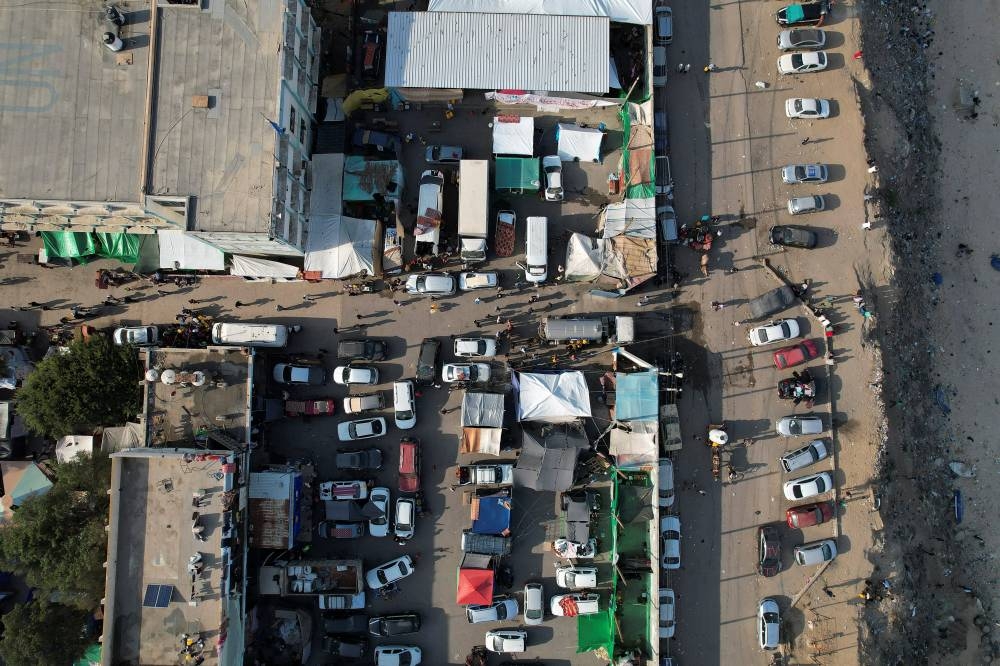 Palestinians gather to collect water from a truck at a United Nations-run school where displaced Palestinians shelter in central Gaza Strip Friday. REUTERS