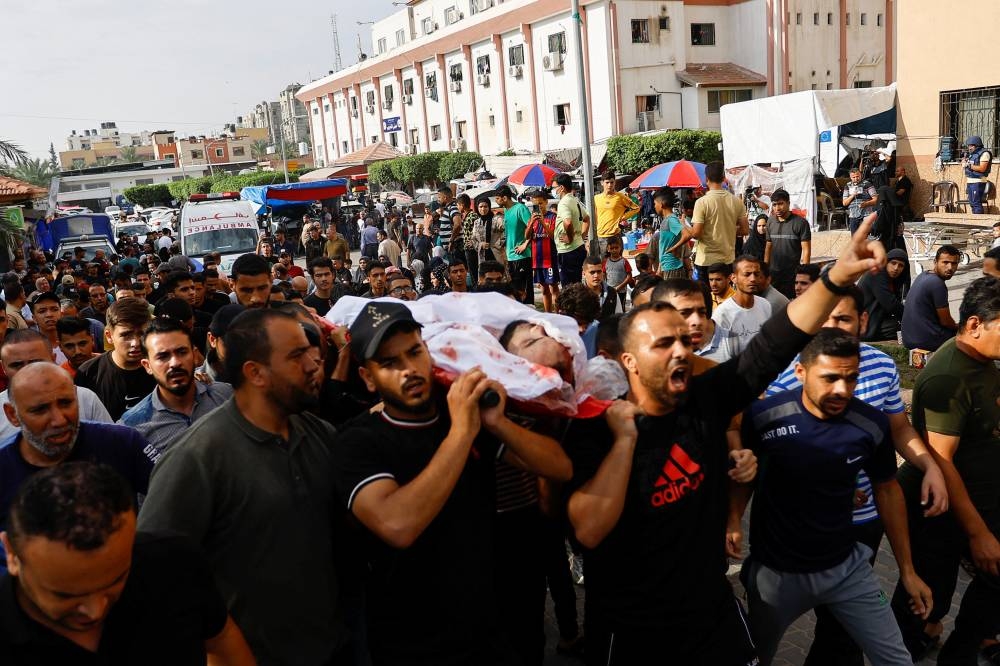 People carry the body of a Palestinian, who was killed in Israeli strikes, during his funeral in Khan Younis, in the southern Gaza Strip, Friday. REUTERS