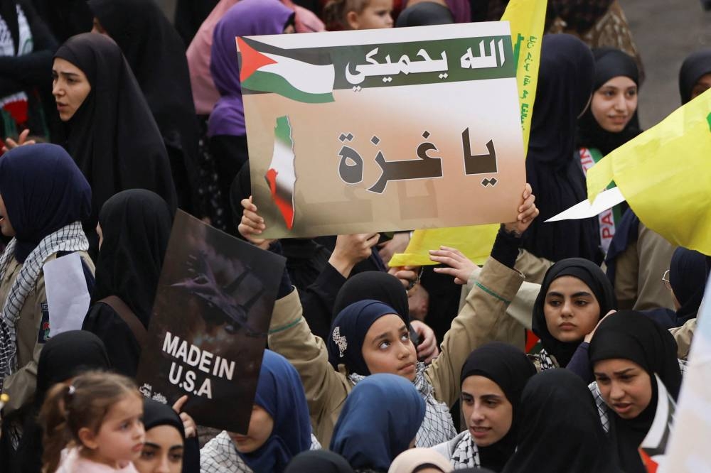People hold placards, as Hezbollah supporters protest in solidarity with Palestinians in Gaza in Beirut, Lebanon, Friday. REUTERS
