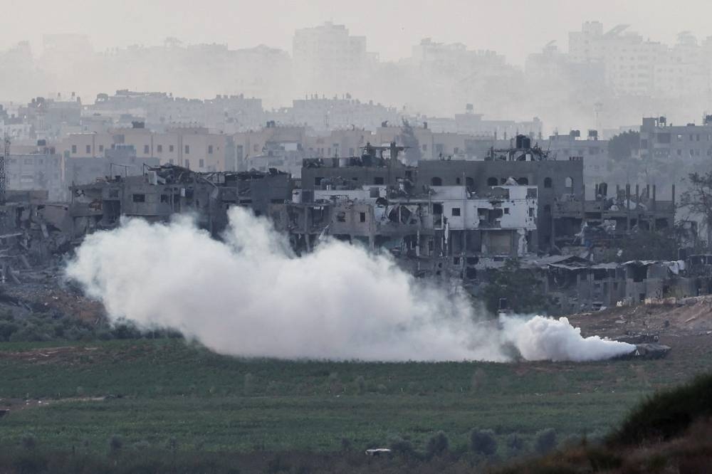 An Israeli tank manoeuvres inside the Gaza Strip, as seen from Israel, Sunday. REUTERS
