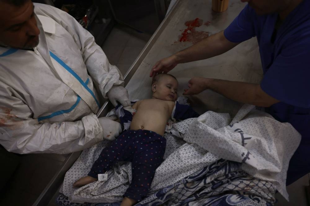 Palestinian baby eight-month-old Sila Abu Amsha is prepared for burial at the Najjar hospital following an Israeli air strike on a home in Rafah, in the southern Gaza Strip on Monday. AFP