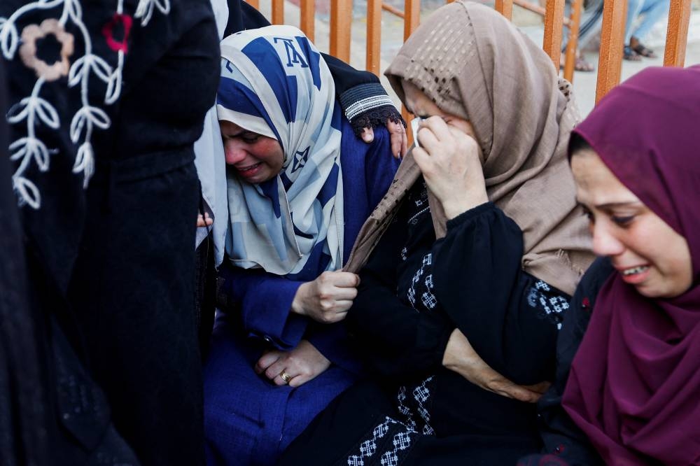 Mourners react during a funeral of Palestinians killed in Israeli strikes, in Khan Younis in the southern Gaza Strip Tuesday. REUTERS