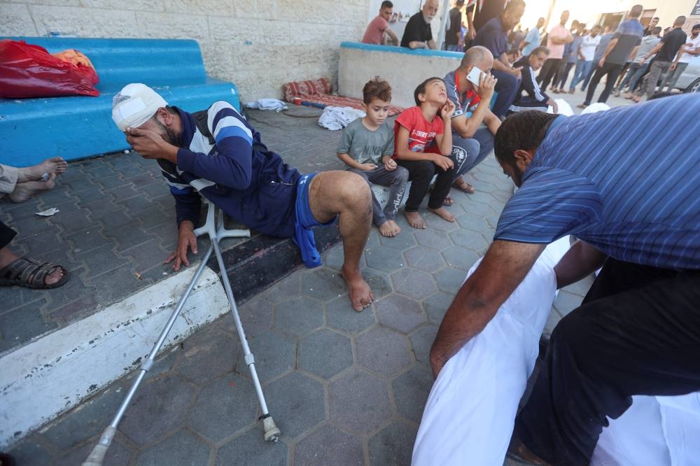 A Palestinian man wounded in Israeli strikes reacts at Shuhada Al-Aqsa hospital in the central Gaza Strip Tuesday. REUTERS
