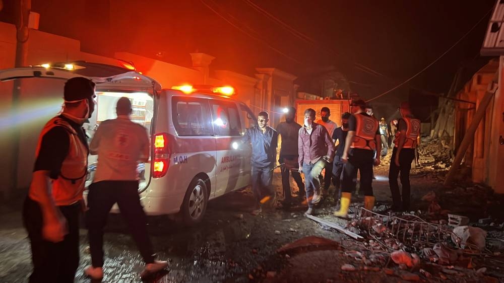 Palestinian medics and rescuers carry a casualty at the site of an Israeli strike on a house in Gaza City Tuesday. REUTERS