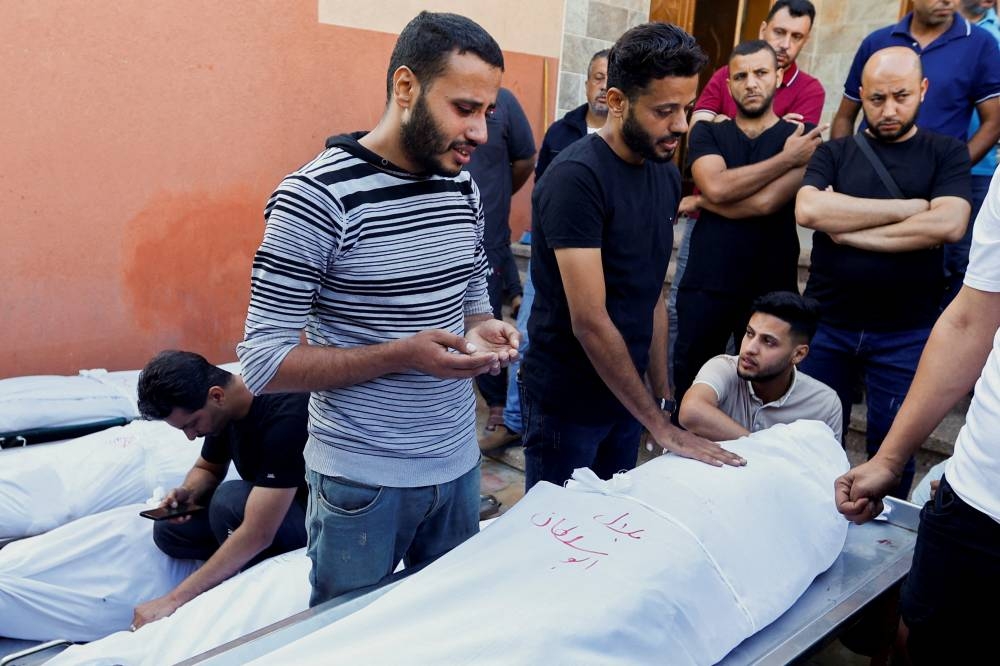 Mourners react next to bodies of Palestinians killed in Israeli strikes during a funeral, in Khan Younis in the southern Gaza Strip Tuesday. REUTERS