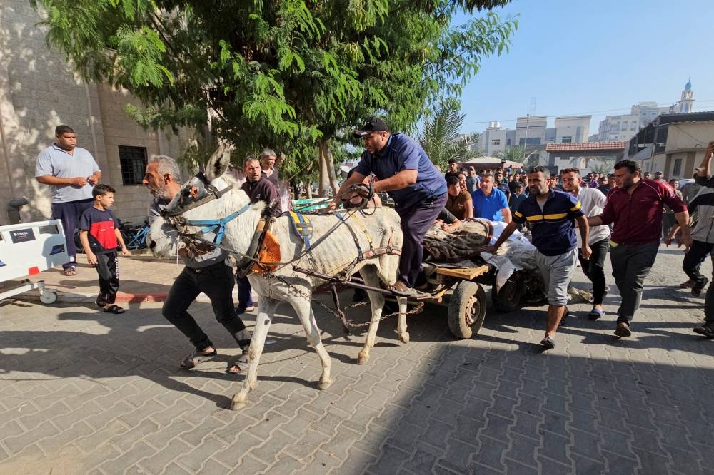 Palestinians transport bodies of people killed by Israeli forces during Israel's ground invasion, on a donkey-drawn cart, near a hospital in Beit Lahiya in the northern Gaza Strip Tuesday. REUTERS