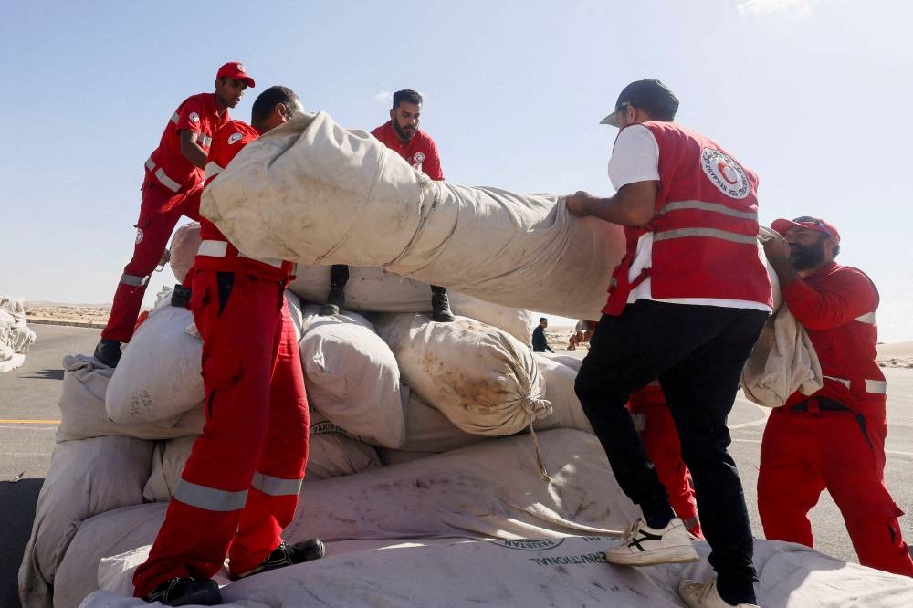 Egyptian Red Crescent members coordinate aid for Gaza, after United Nations Secretary-General Antonio Guterres visited the Rafah border crossing between Egypt and the Gaza Strip, at Al Arish Airport, Egypt, October 20. REUTERS