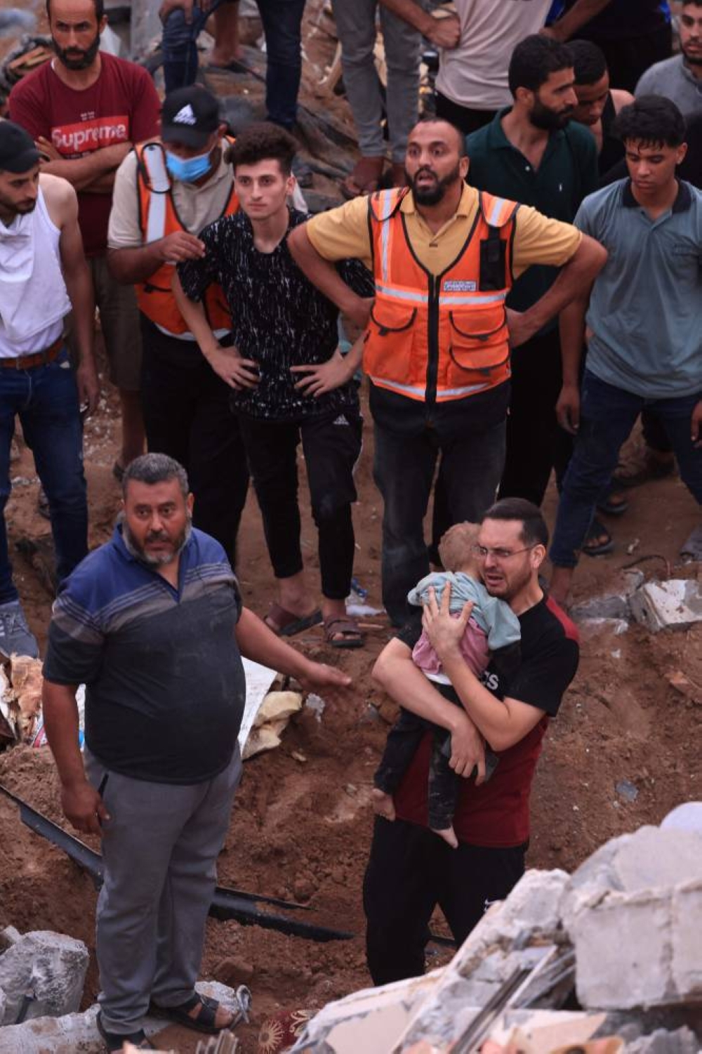 A Palestinian man carries the body of his child after being unearthed from the rubble of a building in the Nuseirat refugee camp, in the central Gaza Strip on Tuesday. AFP