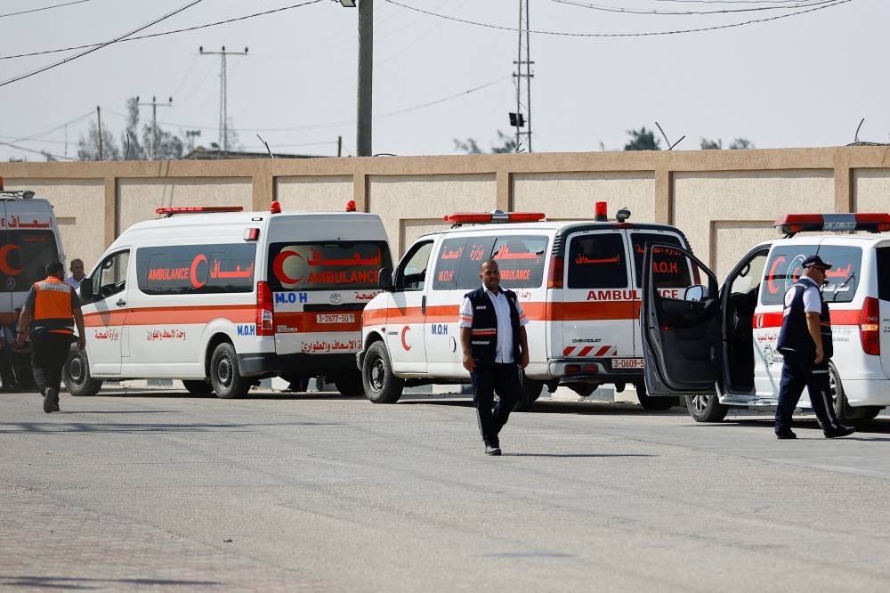 Medical workers wait to take injured Palestinians who will receive treatment in Egyptian hospitals, at the Rafah border crossing with Egypt, in the southern Gaza Strip, on Wednesday. REUTERS