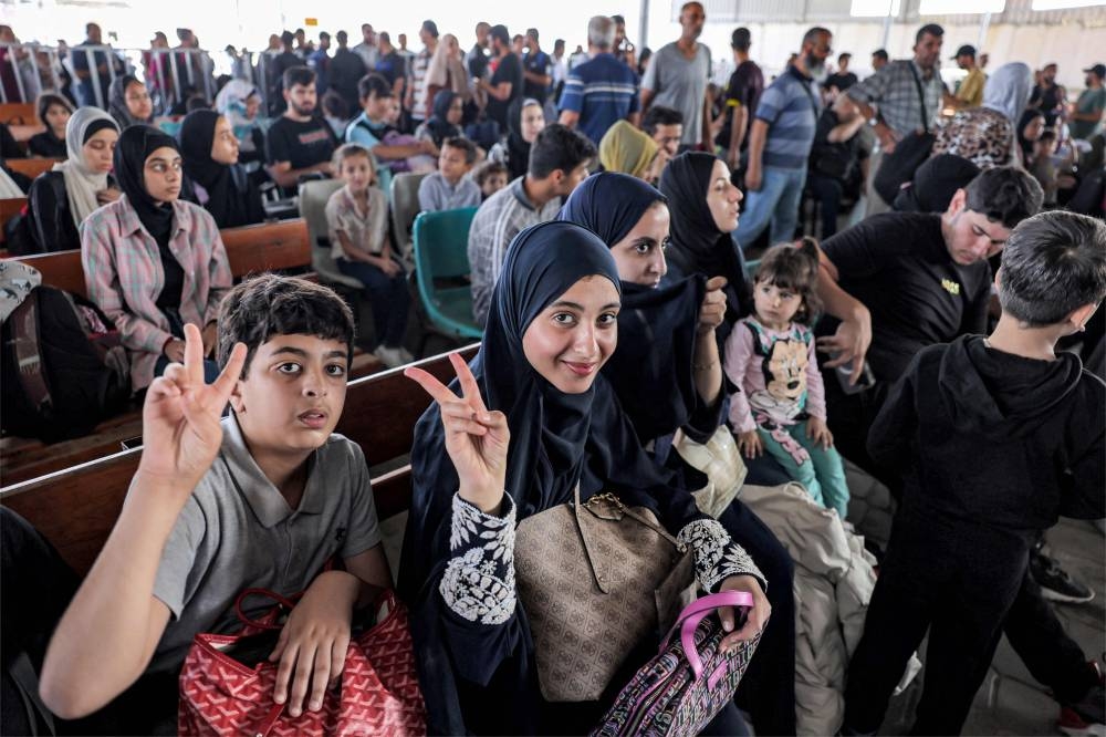 People sit in the waiting area at the Rafah border crossing in the southern Gaza Strip before crossing into Egypt, on Wednesday. AFP