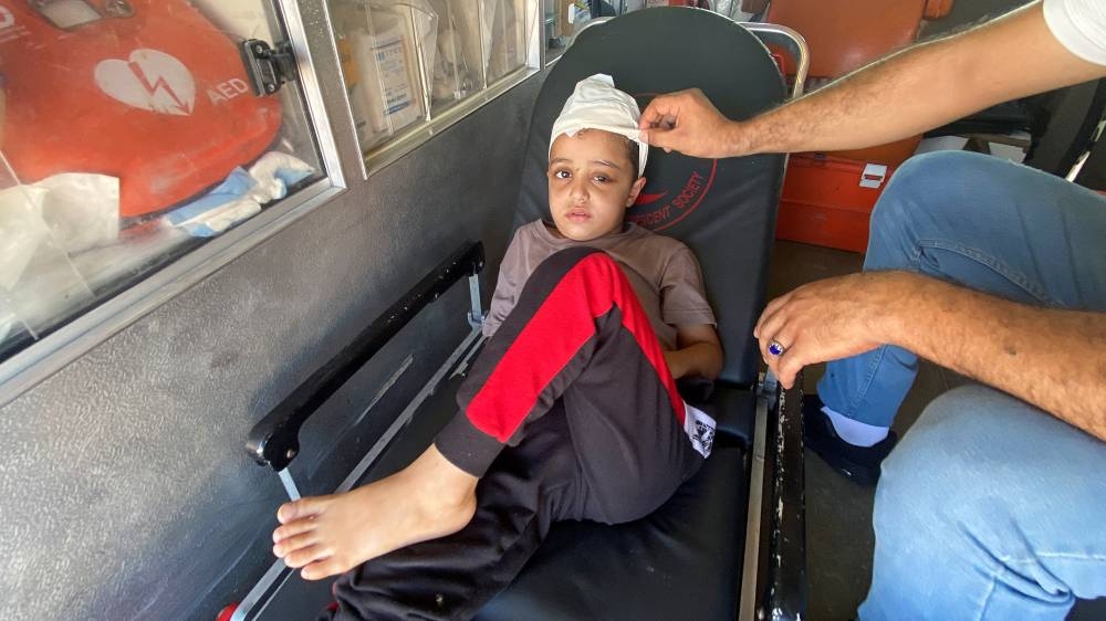 Palestinian boy Ameer Joma, who was injured in an Israeli strike, sits with his father in an ambulance as they wait to be transported for treatment in an Egyptian hospital, at the Rafah border crossing in the southern Gaza Strip, on Wednesday. REUTERS