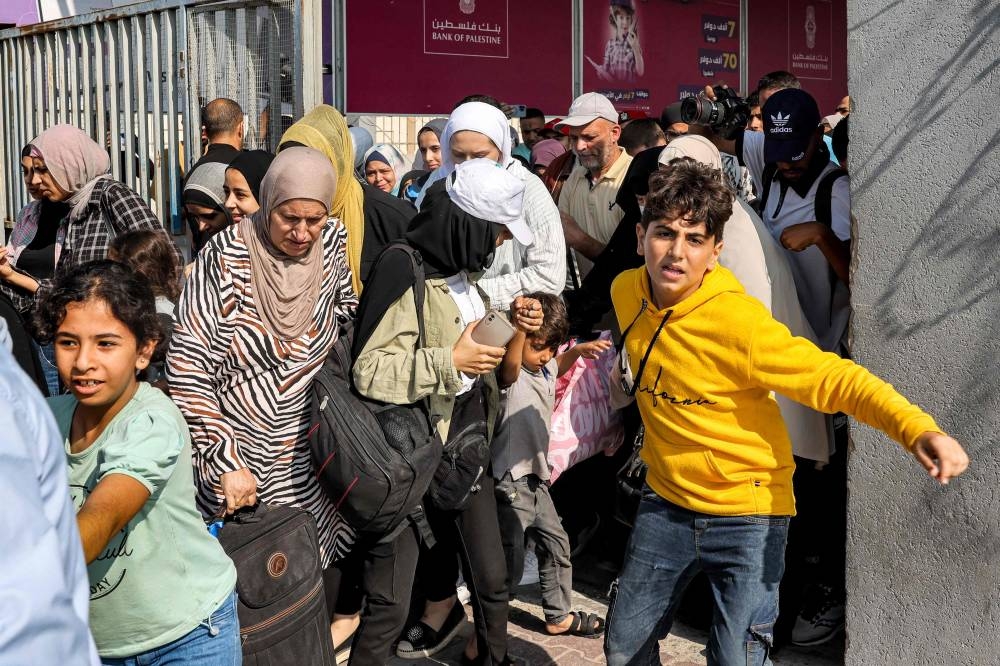 People walk through a gate to enter the Rafah border crossing to Egypt in the southern Gaza Strip, on Wednesday. AFP