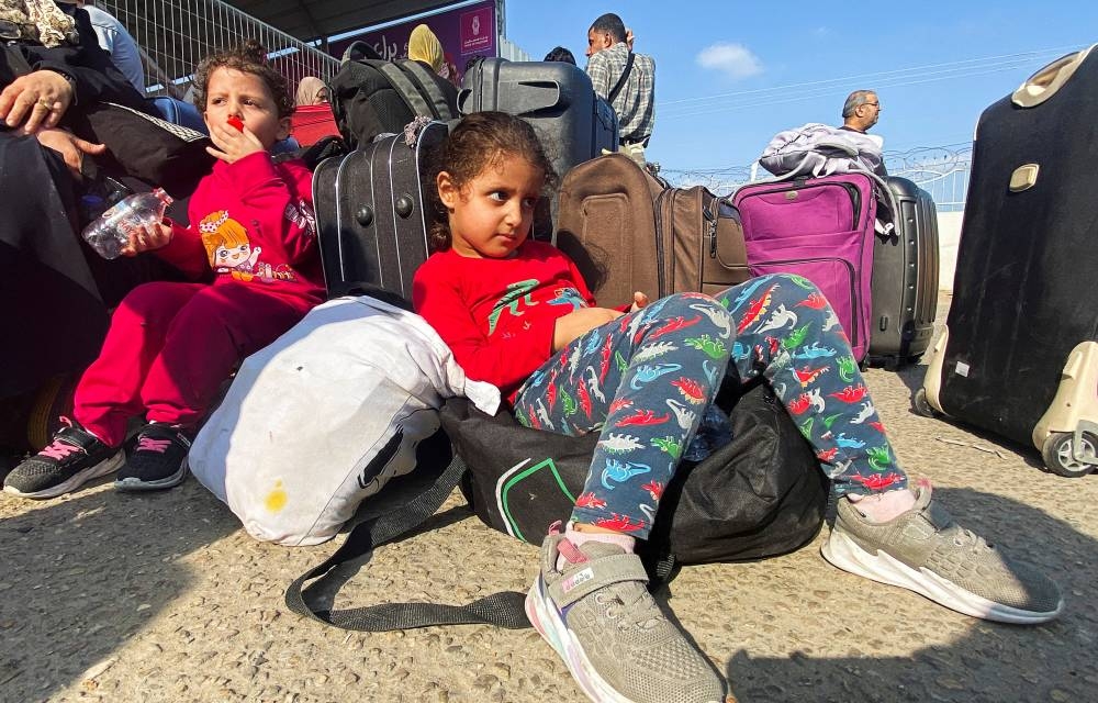 Palestinian children with dual citizenship wait outside the Rafah border crossing with Egypt, in the hope of getting permission to leave Gaza, on Wednesday. REUTERS