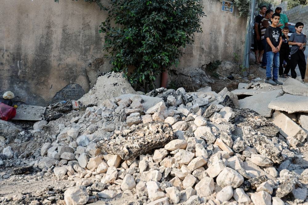 Palestinians check a damaged road after an Israeli raid in Jenin camp in the Israeli-occupied West Bank, Wednesday. REUTERS