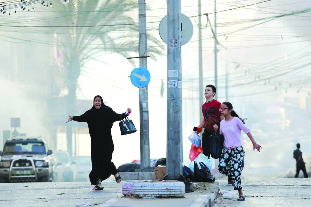 
Palestinians run for cover following a missile strike near Al Shifa hospital in Gaza City. 