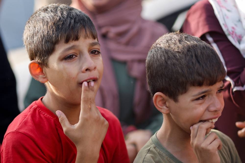 Boys mourn the Palestinians killed during Israeli strikes at a hospital, in Khan Younis in the southern Gaza Strip, on Friday. REUTERS