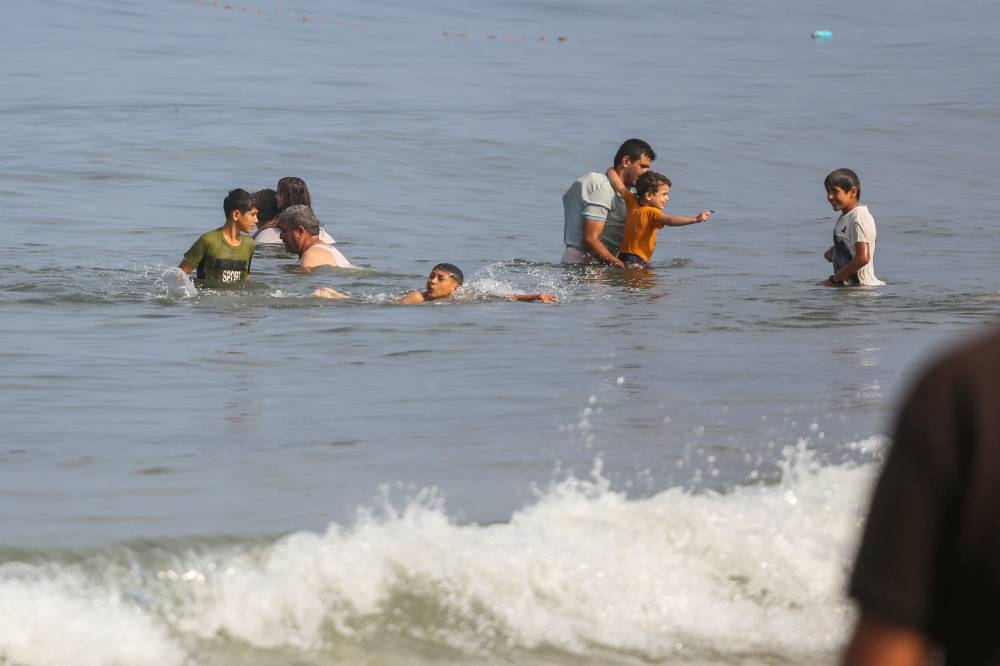 Palestinians wash their bodies at the sea, amid a lack of of clean water, as the conflict between Hamas and Israel continues, in Deir al-Balah, on a beach in the central Gaza Strip, on Thursday. REUTERS