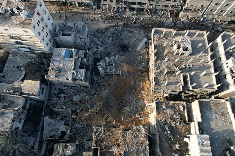 Palestinians gather at the site of Israeli strikes on houses in Maghazi, in the central Gaza Strip, on Friday. REUTERS