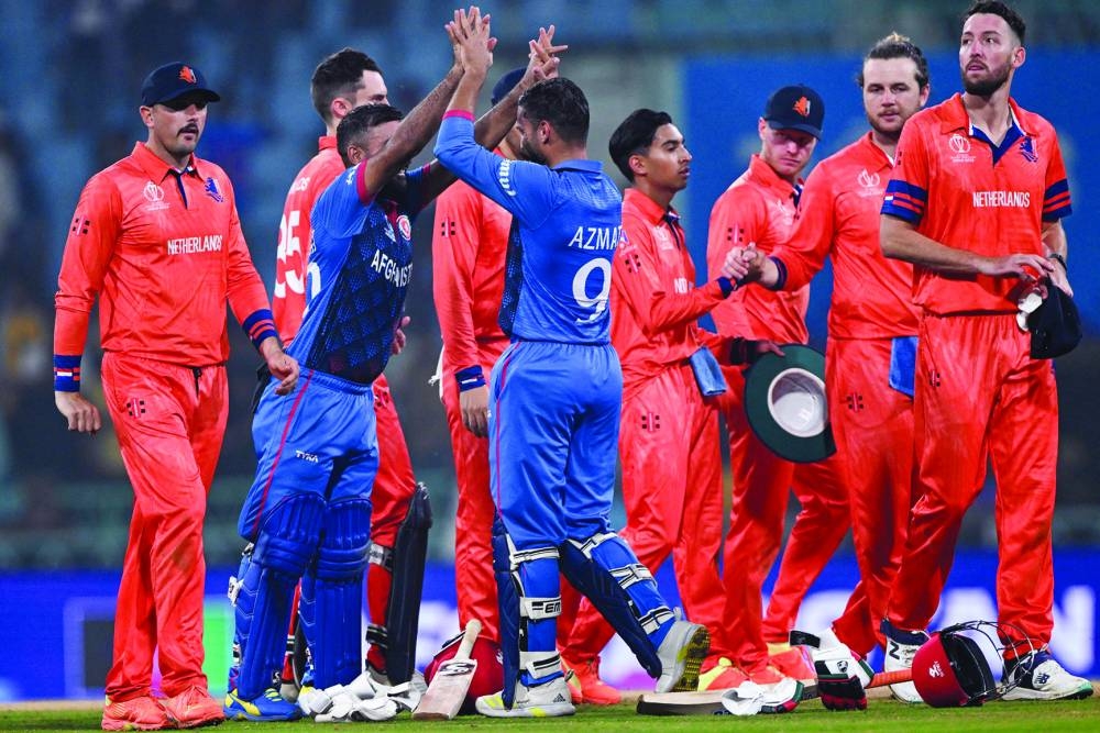 Afghanistan’s captain Hashmatullah Shahidi (second left) and Azmatullah Omarzai celebrate their win at the end of the 2023 ICC World Cup match against Netherlands in Lucknow on Friday. (AFP)