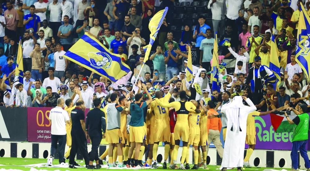 Al Gharafa players celebrate with their fans after beating Al Arabi at the Jassim Bin Hamad Stadium on Friday.