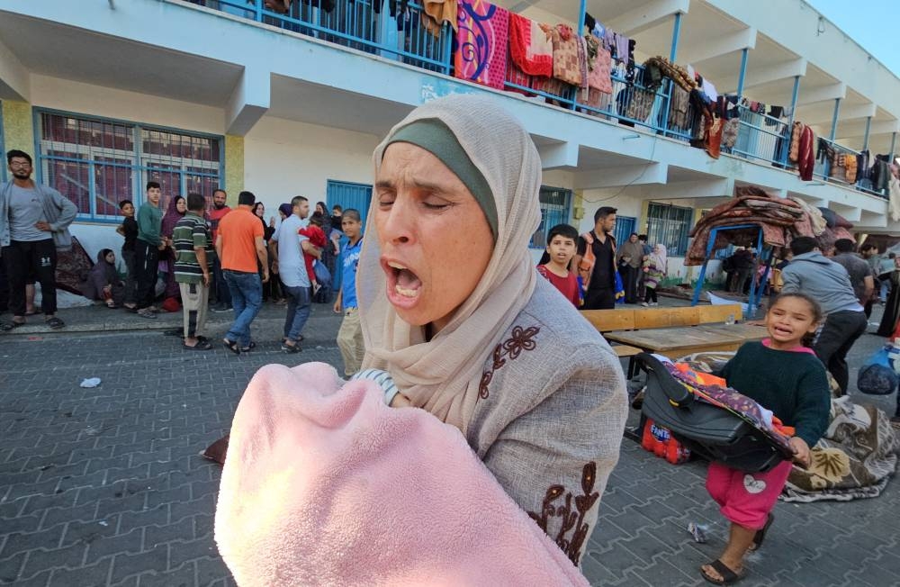 Palestinians react following a strike at a UN-run school sheltering displaced people, amid the ongoing conflict between Israel and Palestinian Islamist group Hamas, in the Jabalia refugee camp in the northern Gaza Strip on Saturday. REUTERS