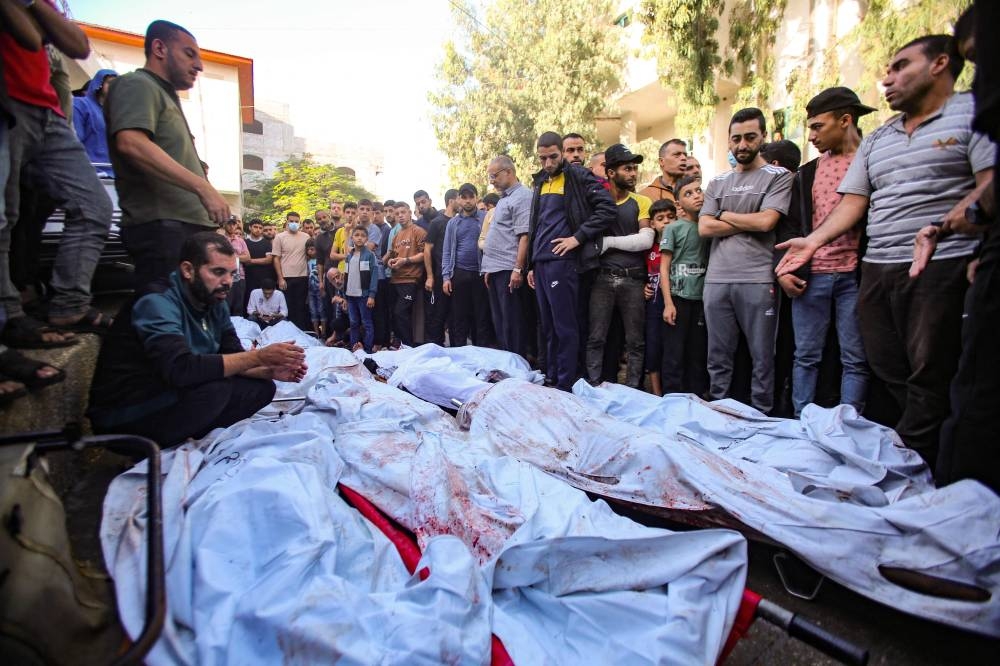 People surround the bodies of people killed a day earlier in an Israeli strike that hit the entrance of Al-Shifa hospital in Gaza City, during a funeral held for the victims on Saturday. AFP