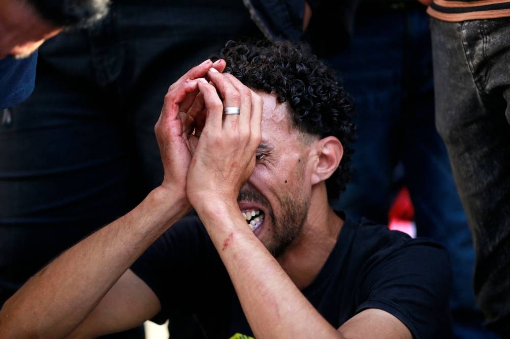 The relative of a victim killed a day earlier in an Israeli strike that hit the entrance of Al-Shifa hospital in Gaza City, mourns at a funeral held for the victims on Saturday. AFP