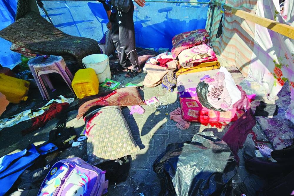 
Belongings of Palestinians lie on the ground following a strike at a UN-run school sheltering displaced people, in the Jabalia refugee camp in the northern Gaza Strip, yesterday. 