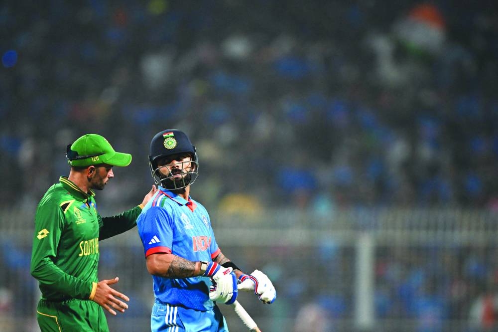 South Africa’s Keshav Maharaj (left) greets India’s Virat Kohli on scoring a century during the ICC World Cup match at the Eden Gardens in Kolkata on Sunday. (AFP)