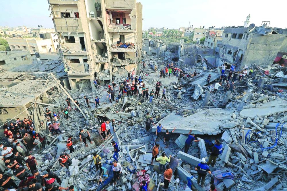 
People check the damage caused by an Israeli strike on the Al Maghazi refugee camp in Deir Balah in the central Gaza Strip, yesterday. 