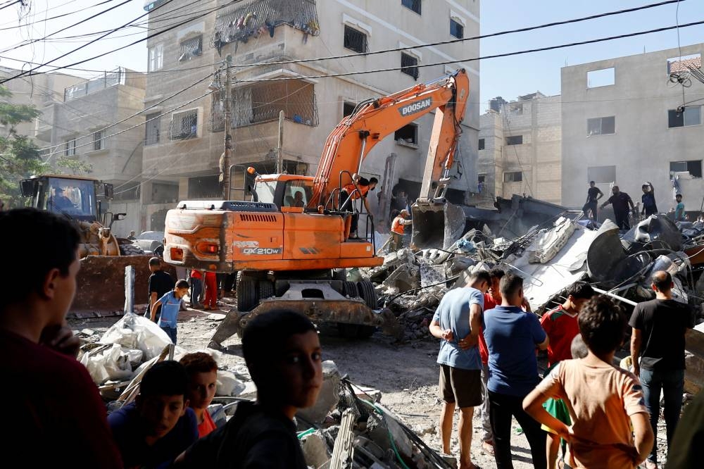Palestinians search for casualties at the site of an Israeli strike on a house in Khan Younis in the southern Gaza Strip, Monday. REUTERS