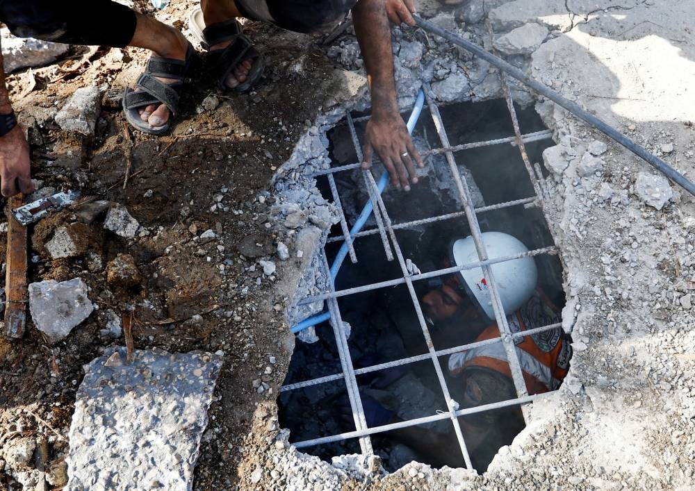 Palestinians search for casualties at the site of an Israeli strike on a house in Khan Younis in the southern Gaza Strip, Monday. REUTERS