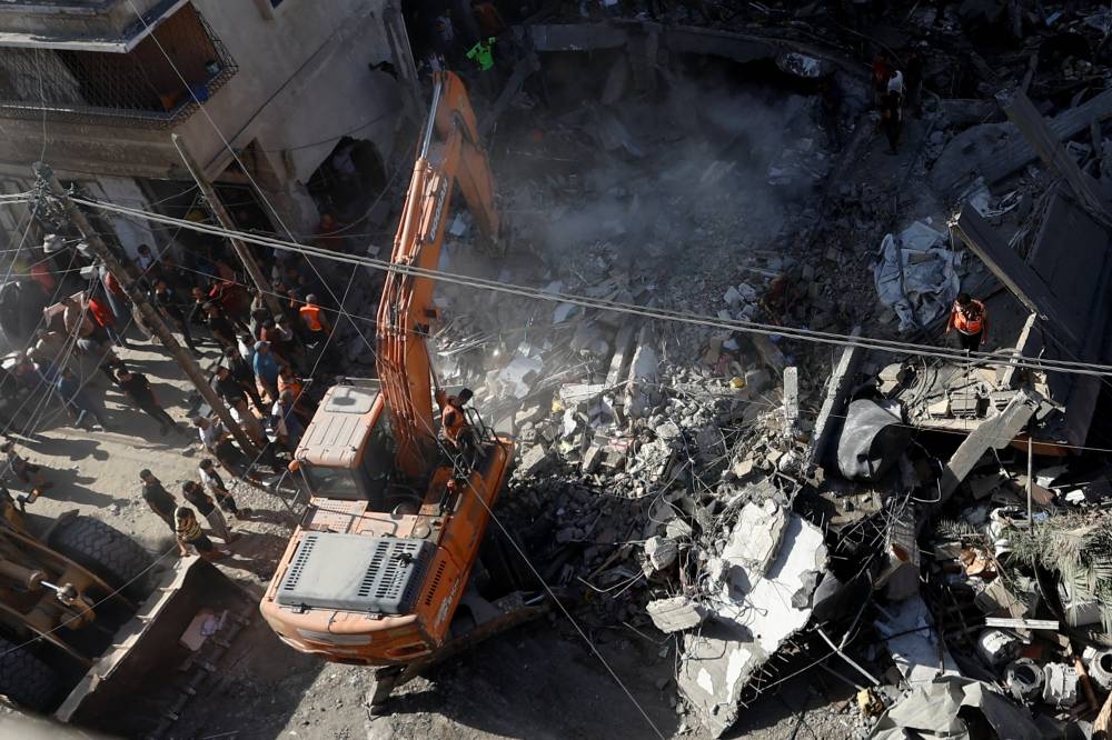 Palestinians search for casualties at the site of an Israeli strike on a house in Khan Younis in the southern Gaza Strip, Monday. REUTERS